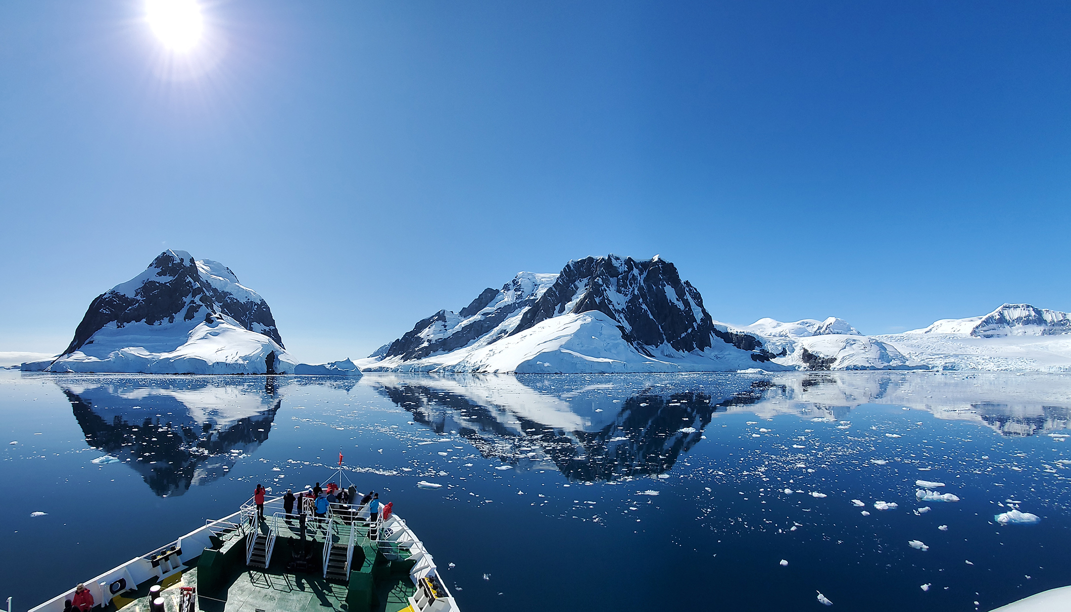 Large ship cruising through mountains in Antarctica