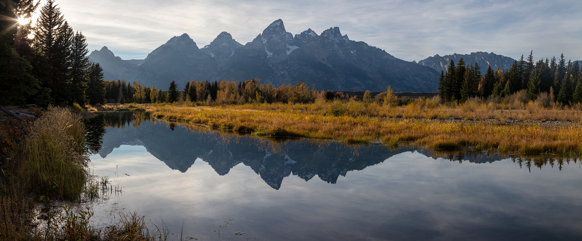 Photograph of the Grand Teton mountain range with a reflection over a river