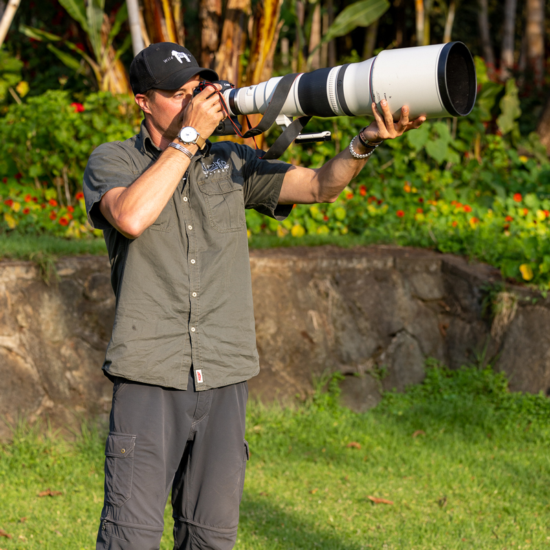 Nature photographer Derek Nielsen holding a 600mm lens to photograph birds