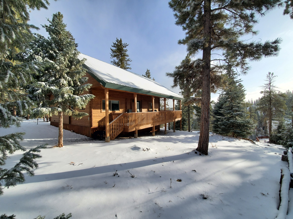 Image of a cabin in Duck Creek Village Utah in the winter with the ground and roof covered in show