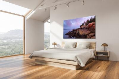 large print of Bass Harbor Lighthouse in Maine displayed above the bed in a modern home