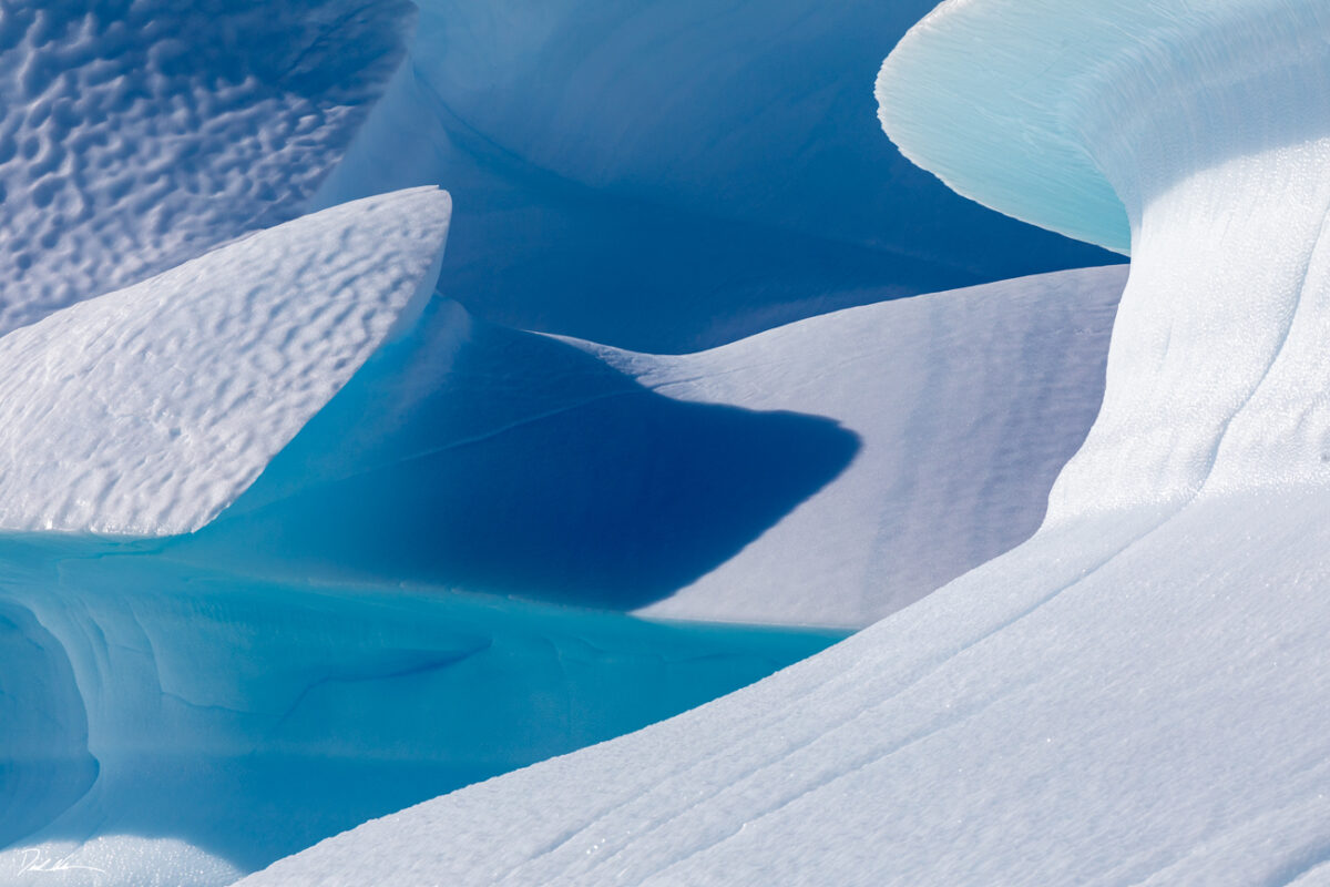 abstract image of ice in Antarctica with various curves and deep blue colors