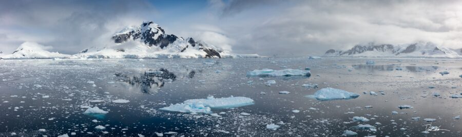 panoramic image of the sea in Antarctica with mountains and clouds in the background