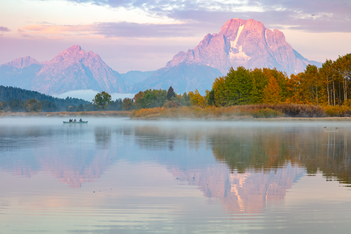 Image of Oxbow Bend during sunrise with a canoe on the water during fall 