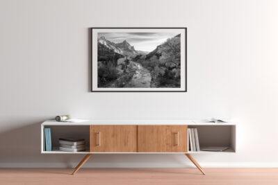 black and white photo river through mountains