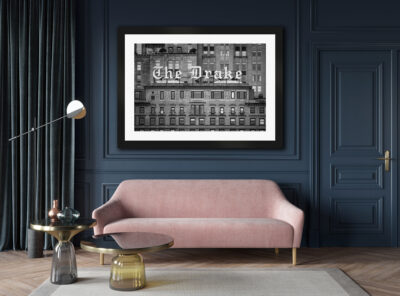 Large framed black and white image of the Drake Hotel in Chicago displayed above a pink couch in a classy living room