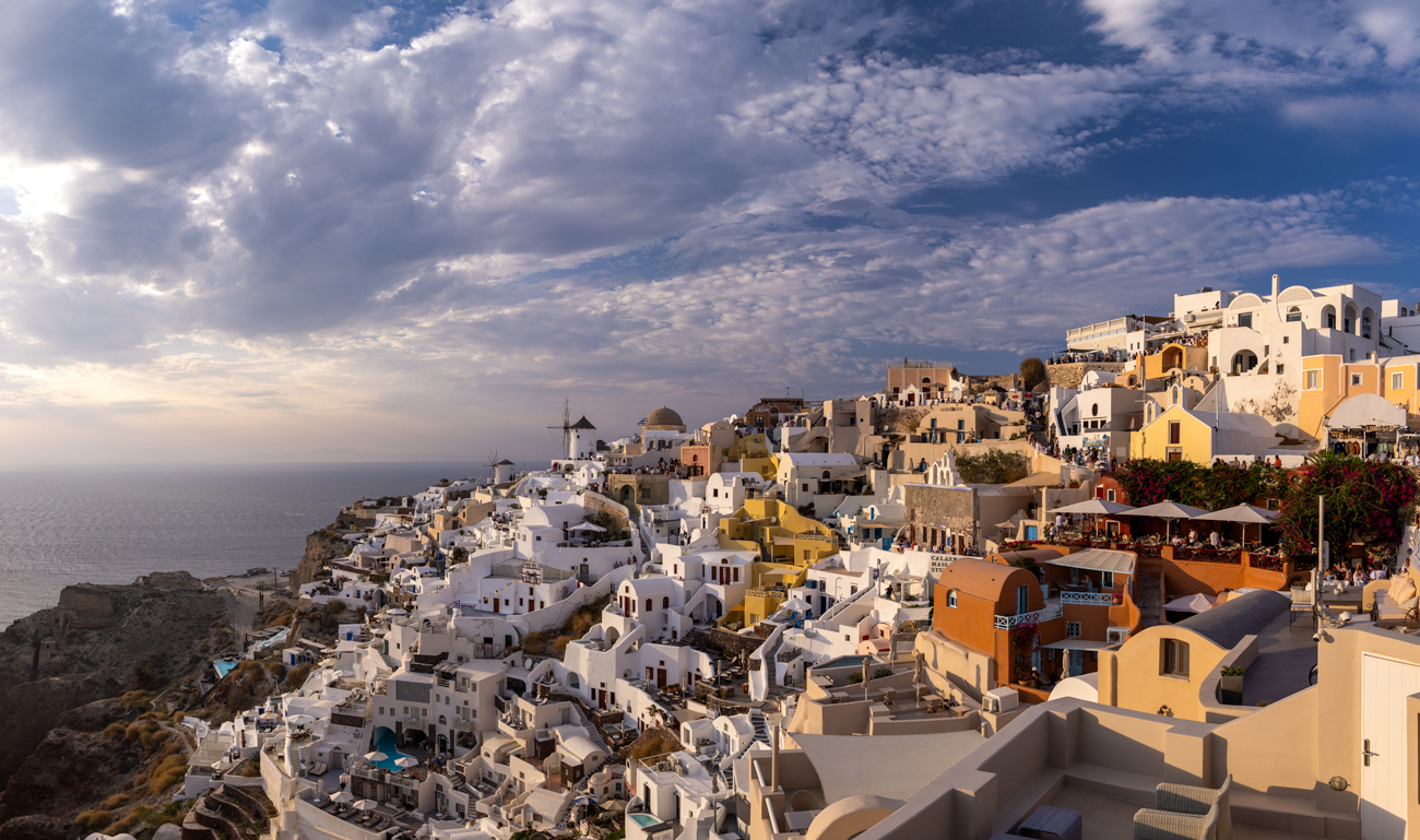 Sunset image of Oia in Greece with dramatic clouds above the seaside village