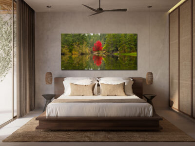 Large unframed panoramic image of a maple tree standing out in a green forest displayed above a bed in a modern bedroom