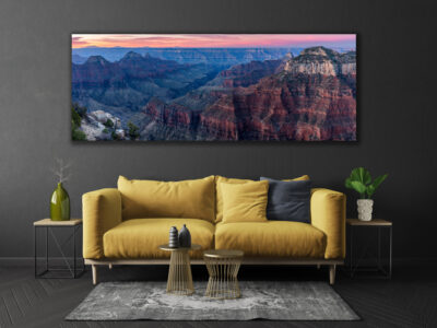 Large unframed panoramic print of the Grand Canyon at sunset displayed above a couch in a modern home
