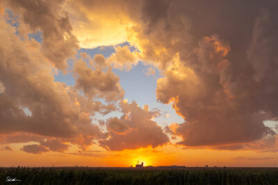 image of a beautiful sunset over the heartland of America during sunset with a farm in front of the sun