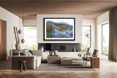Large framed fine art print of a wintery fall scene in Telluride Colorado displayed above the couch of a modern mountain home
