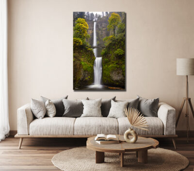 large vertical fine art print of Multnomah Falls in Oregon displayed above a couch in a modern home