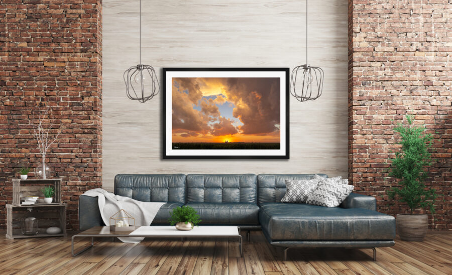Large framed image of a farm taken at sunset displayed in the living room of a modern home