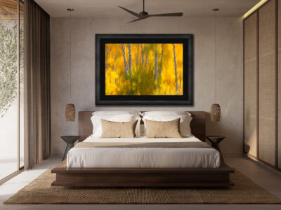 Large framed fine art print of aspen trees reflecting off the pond displayed in the room of a modern hotel