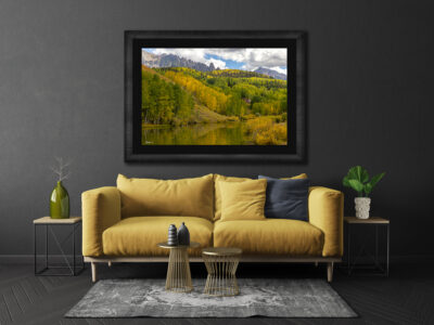 Large framed fine art print of a mountain scene displayed above the couch of a modern home