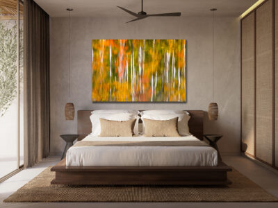 large unframed fine art print of aspen trees reflecting off a lake displayed above a bed in a luxury hotel