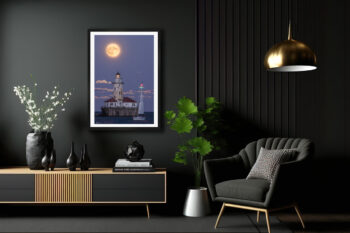 large fine art framed print of a super moon rising behind Chicago's Navy Pier lighthouse with a sailboat crossing in front displayed in the living room of a luxury home