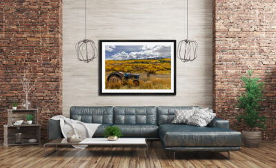 Large framed fine art image of a tractor in Telluride, Colorado, during fall displayed in the living room of a modern apartment