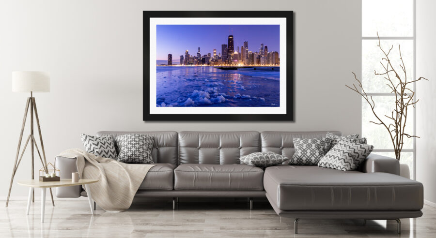 Large framed fine art print of Chicago during a winter sunrise displayed above the couch in a modern living room