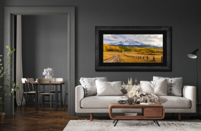 large framed image of Wilson Peak in Telluride Colorado displayed above a couch in a living room