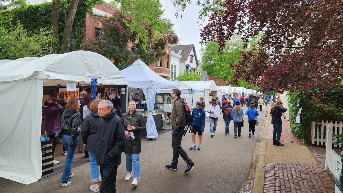 Image of Old Town Art Fair in Chicago and Derek Nielsen's photography booth in front with people walking through the streets