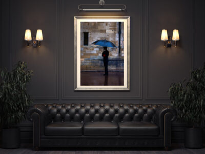 Large framed fine art print of a woman holding an umbrella in the rain at Windsor Castle displayed in a hotel lobby