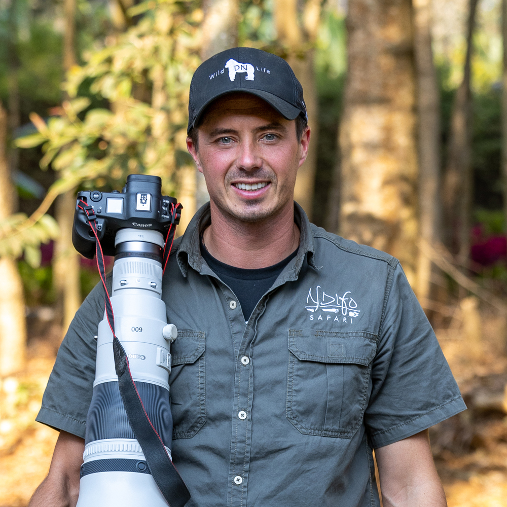 photo of photographer Derek Nielsen holding a 600mm lens on safari
