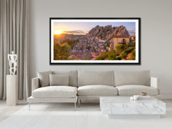 Large framed image of the small mountian town of Pietrapertosa in Italy displayed above the couch in the living room of a moder luxury home