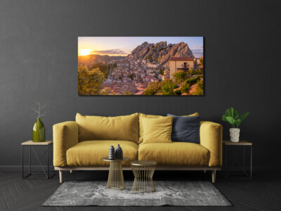 Large unframed image of the small mountain town of Pietrapertosa in Italy displayed above the couch in the family room of a modern home