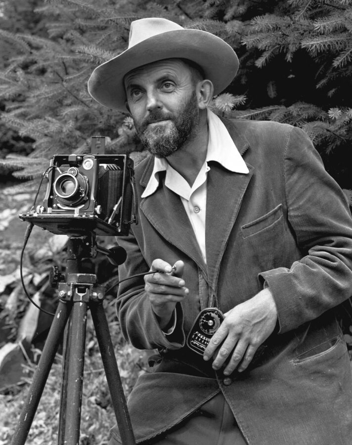 Black and white photograph of Ansel Adams with his camera 