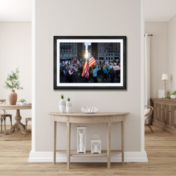 Large framed fine art piece of protesters with the american flag walking through the streets of Chicago displayed in the hallway of a modern home
