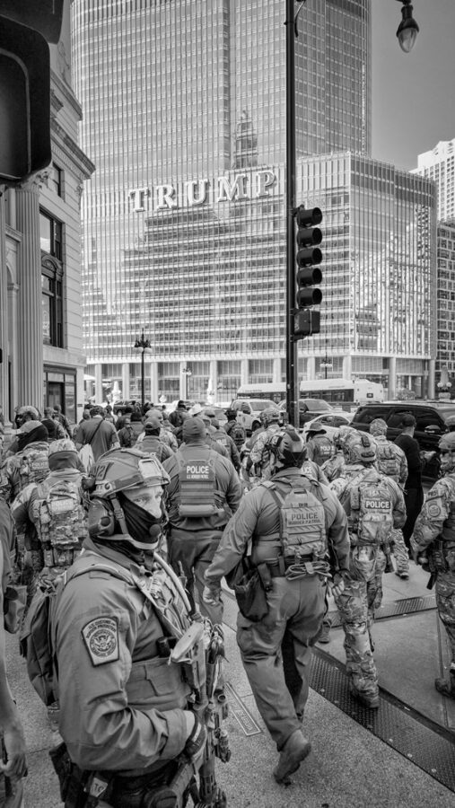 Photograph of ICE agents walking through downtown chicago by the Trump tower