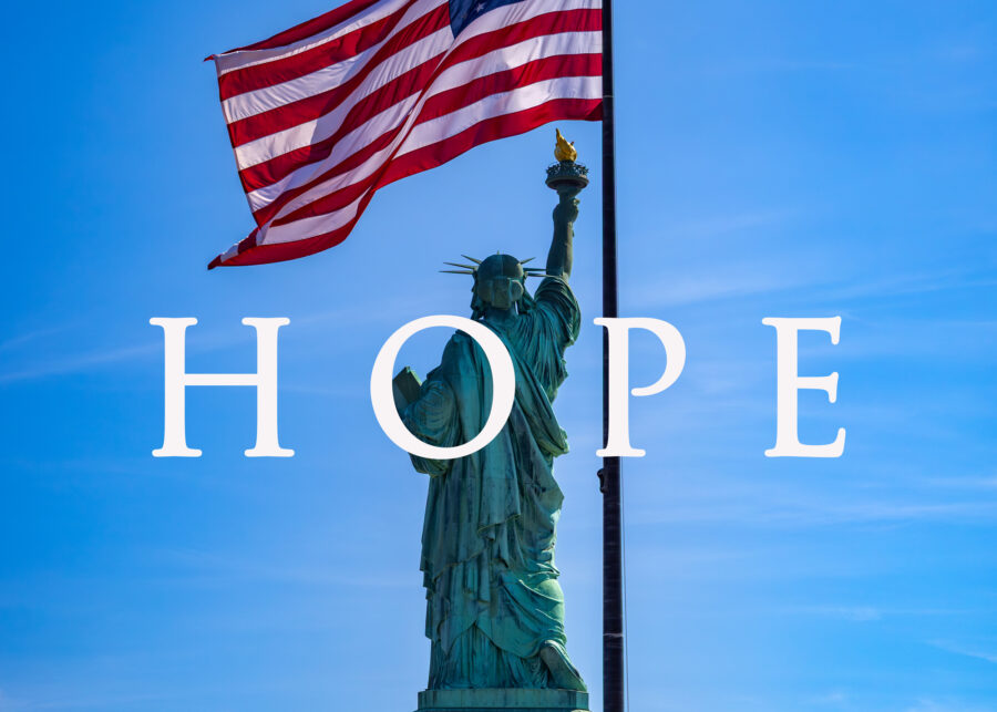 a photograph of the statue of liberty and the american flag with the words hope in front