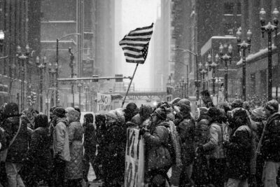 Black and white photograph of protesters marching through the streets of Chicago