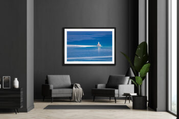 large fine art photograph of a lone lighthouse on a deep blue Lake Michigan during winter displayed in a modern home.