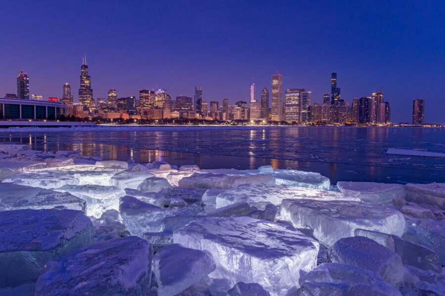 Skyline shot of Chicago with large ice blocks in the foreground lit from behind by light