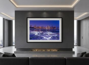 large framed fine art print of the Chicago skyline with large iceblocks in the foreground with lights behind them displayed in the living room of a luxury home.
